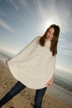 densely knitted circular cable knit poncho with roll neck